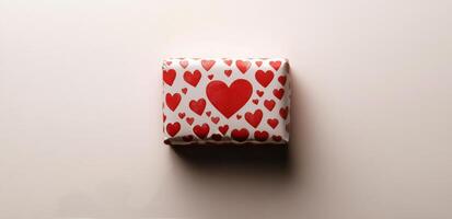 A beautifully wrapped gift with red heart patterns ready for a romantic occasion photo