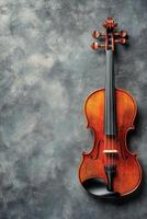 A beautifully crafted violin rests against a textured gray background with elegant detailing photo