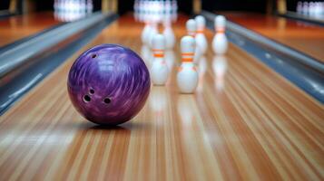 Purple bowling ball rolling down lane with pins in background at bowling alley during evening hours photo