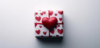 A beautifully wrapped gift with red heart patterns ready for a romantic occasion photo