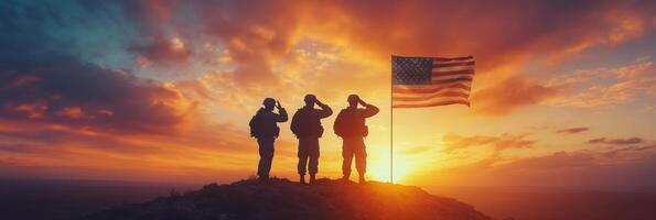 Three soldiers stand on a hillside, saluting while holding an American flag during a stunning sunset photo