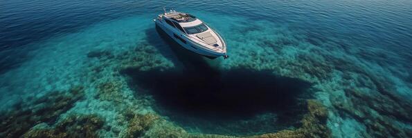 A luxury yacht cruises through clear blue waters on a sunny day in a tropical location photo