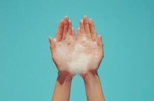 Hands holding two natural soap bars against a blue background during a bright indoor setting photo