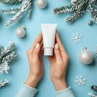 Winter skincare routine with a moisturizer tube and holiday decorations on a blue background photo