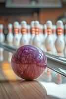 A vivid bowling ball perched atop a purple cube in a lively bowling alley during the evening photo