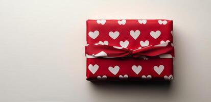 A beautifully wrapped gift with red heart patterns ready for a romantic occasion photo
