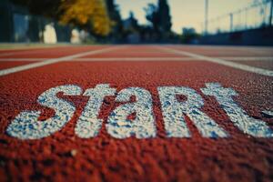 Close up of a weathered track start line marked on a red surface during early morning light photo