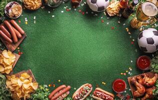 Gathering of snacks and drinks for a football match viewing party on green grass photo