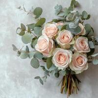 Elegant bouquet of soft pink and cream roses with eucalyptus leaves arranged for special occasions photo