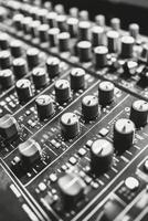 Detailed close up of a mixing console with black knobs used in music production photo