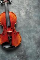 A beautifully crafted violin rests against a textured gray background with elegant detailing photo