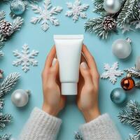 Winter skincare routine with a moisturizer tube and holiday decorations on a blue background photo