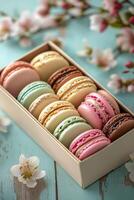 Colorful macarons arranged in a decorative box with flowers on a rustic wooden table photo