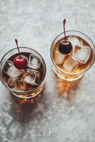 Two refreshing cocktails with cherries served on ice in stylish glasses on a marble surface photo