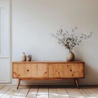 Modern wooden sideboard with decorative plants and vase against a minimalist wall photo