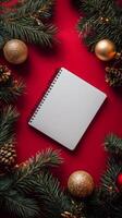 Blank notepad surrounded by festive decorations on a red background during the holiday season photo