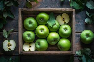 Fresh green apples in a wooden crate surrounded by leaves on a rustic surface photo