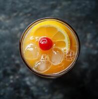 Refreshing cocktail served in a glass with ice and garnished with a cherry and lemon slice photo