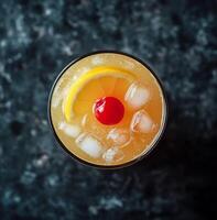 Refreshing cocktail served in a glass with ice and garnished with a cherry and lemon slice photo
