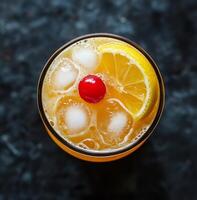 Refreshing cocktail served in a glass with ice and garnished with a cherry and lemon slice photo