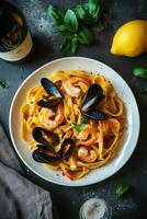 Delicious seafood fettuccine served in a bowl with lemon on a wooden table photo