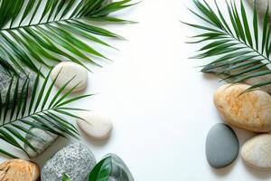 Natural arrangement of smooth stones and green palm leaves on a light background photo