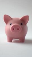 A pink piggy bank stands on a light background, representing savings and financial goals photo