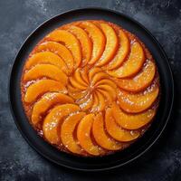 Delicious peach upside down cake served on a black plate in a modern kitchen setting photo