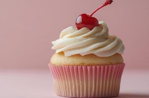 Delicate vanilla cupcake topped with whipped cream and cherry on light pink background photo