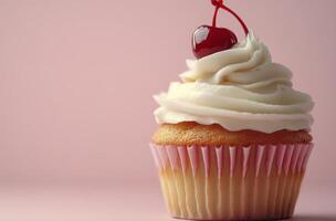 Delicate vanilla cupcake topped with whipped cream and cherry on light pink background photo