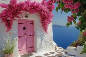 Charming pink door framed by vibrant bougainvillea near the stunning coast in Santorini, Greece photo