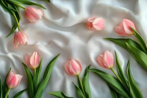 Elegant pink tulips on soft white fabric, capturing springtimes beauty and freshness photo