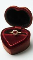 Elegant heart shaped ring box with a ruby and diamond engagement ring inside it photo
