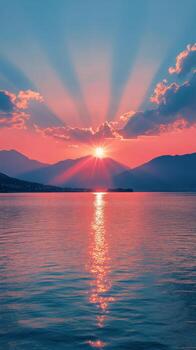 A beautiful sunset over a tranquil lake with vibrant colors and mountainous backdrop photo