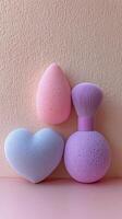 Colorful beauty sponges arranged on a soft pink background with varying shapes and sizes photo