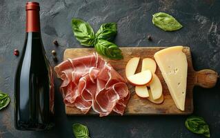 Cured meats, apple slices, basil, and red wine on a wooden board photo