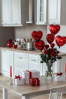 Celebratory kitchen setting with heart shaped balloons and romantic decorations on table photo