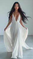 A model walks confidently in a flowing white gown, showcasing elegance and grace in soft lighting photo
