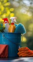 Cleaning supplies in a blue bucket placed by the window with bokeh background on a sunny day photo