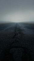 Dark and moody cracked road under stormy sky at dusk with ominous clouds gathering photo