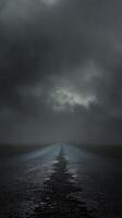 Dark and moody cracked road under stormy sky at dusk with ominous clouds gathering photo