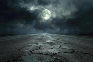 A narrow road stretches into the distance under a bright full moon and dark storm clouds at night photo