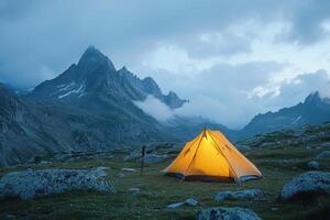 A solitary tent glows warmly in a misty mountain landscape during twilight hours photo