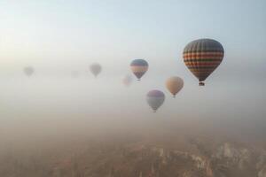 Hot air balloons float over the stunning rock formations of Cappadocia at sunrise on a clear morning photo