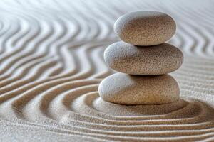 Tranquil stacked stones on a sandy surface with gentle ripples in the background photo