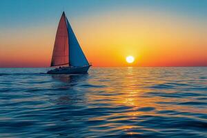 A sailboat gliding across calm waters at sunset with vibrant colors on the horizon photo