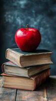 Red apple resting on vintage books stacked on a wooden table in a cozy reading nook photo