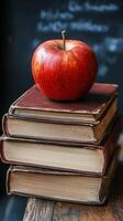 Red apple resting on vintage books stacked on a wooden table in a cozy reading nook photo