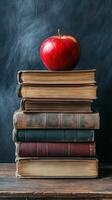 Red apple resting on vintage books stacked on a wooden table in a cozy reading nook photo