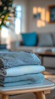 A stack of neatly folded fabrics in a cozy living room with a warm atmosphere photo